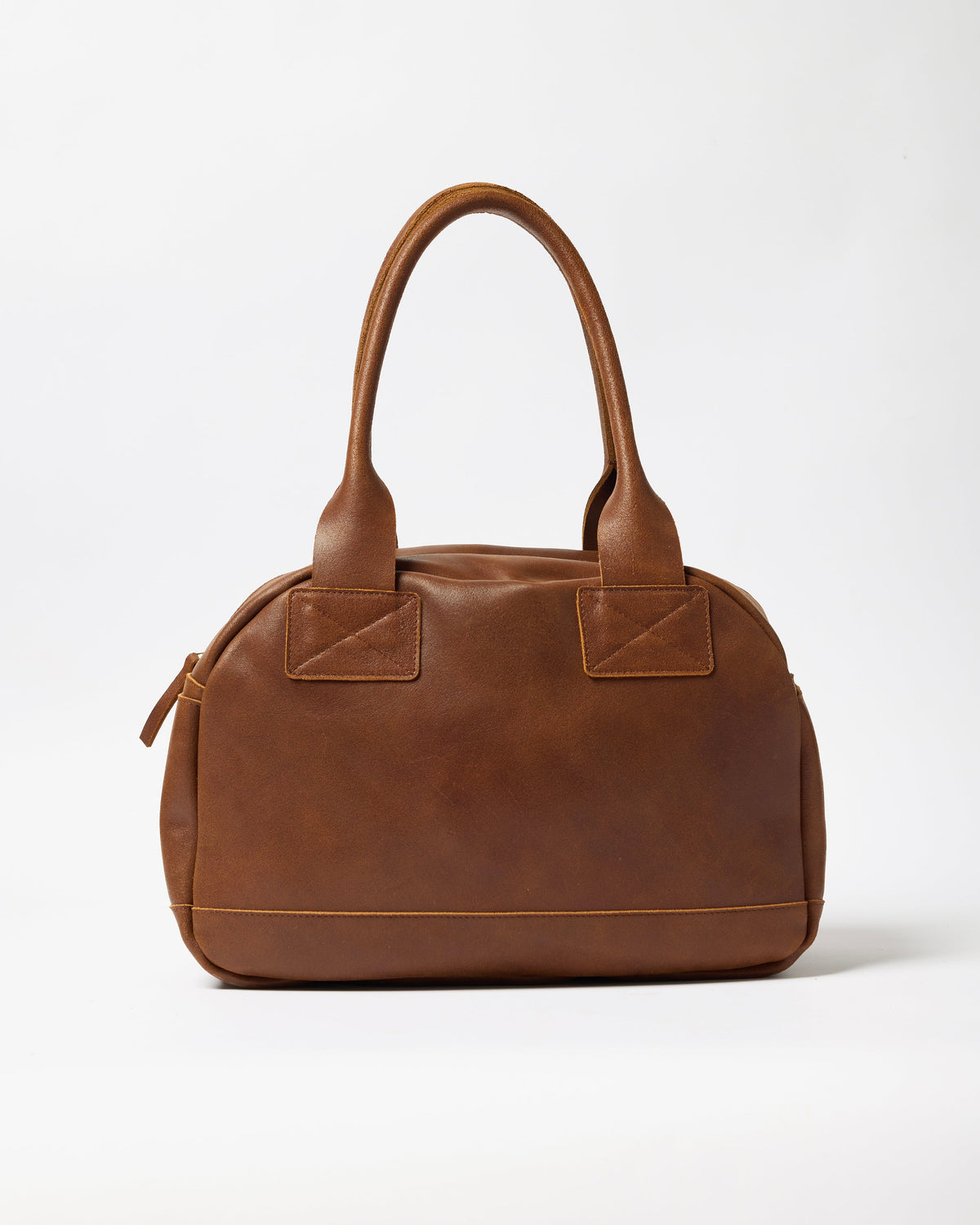 A brown leather handbag with double top handles, a zippered side pocket, and decorative stitched details on a clean white background.
