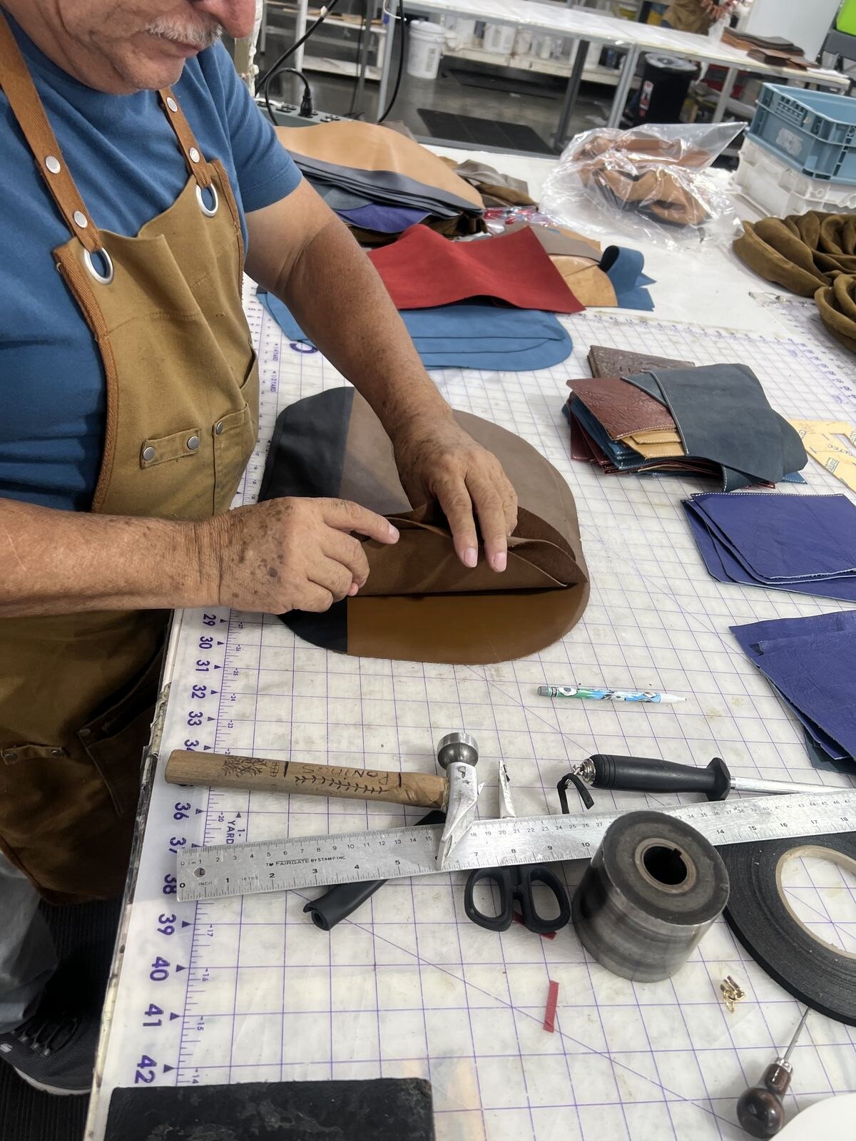 La Lune artisan hand-cutting deadstock leather in the Los Angeles workshop